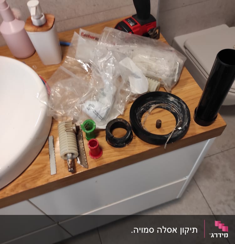כלי עבודה וחלקי אינסטלציה על שולחן עץ בחדר אמבטיה